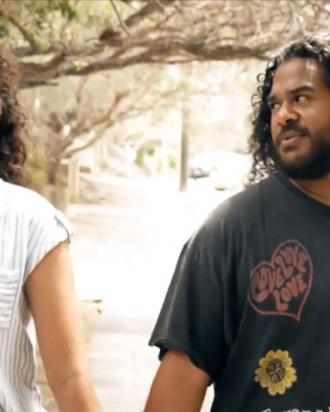 Two young people walking while holding hands outside